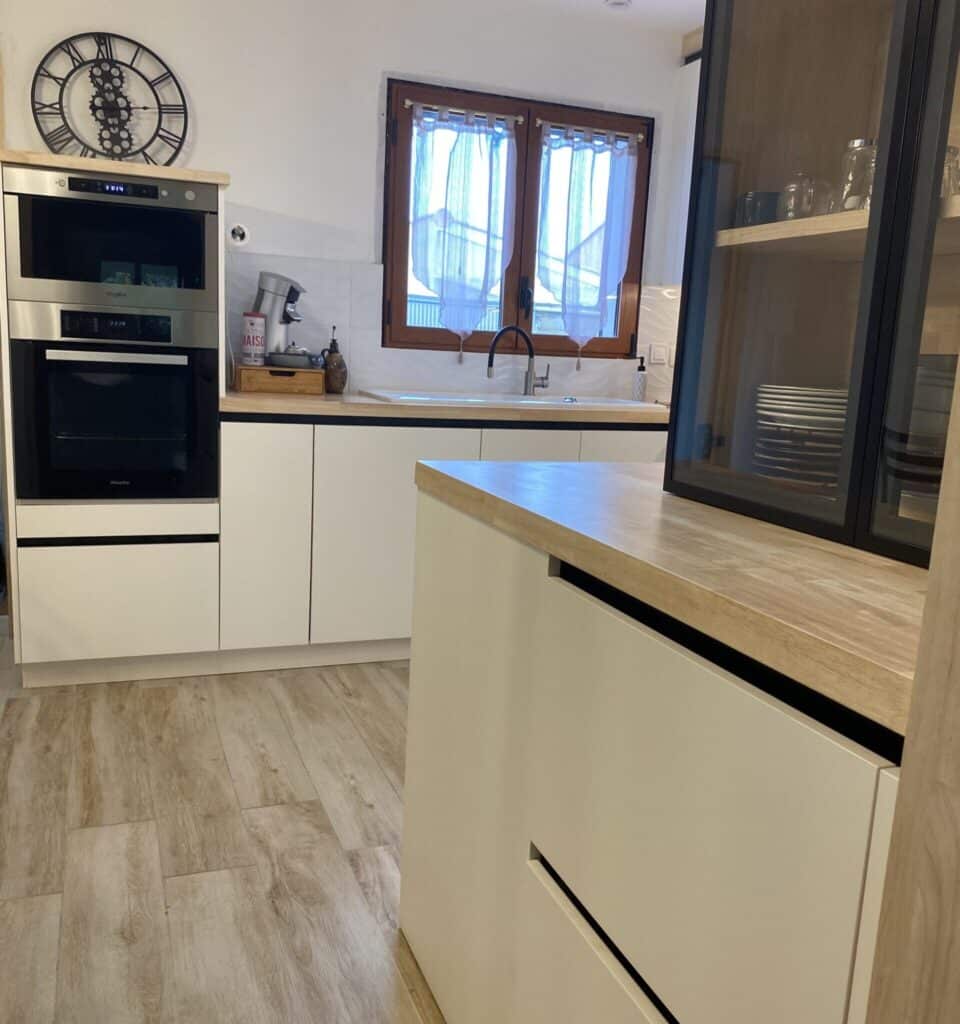 Cuisine Moderne : Design Épuré, Four Miele & Micro-ondes Whirlpool Cuisine moderne épurée avec four Miele, micro-ondes Whirlpool (13:14), horloge, évier, et meuble vitré. Plans de travail bois, armoires claires, texte "MAISON".